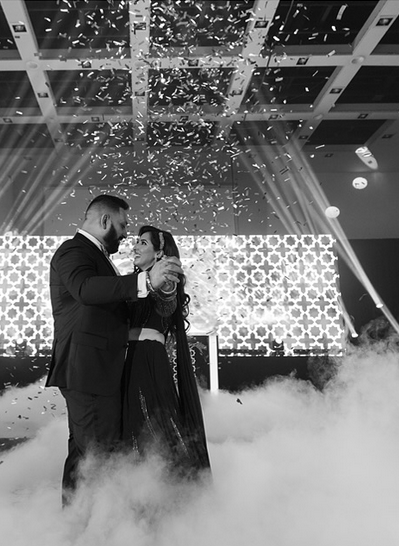 Couple dancing at Maharaja event with confetti and fog