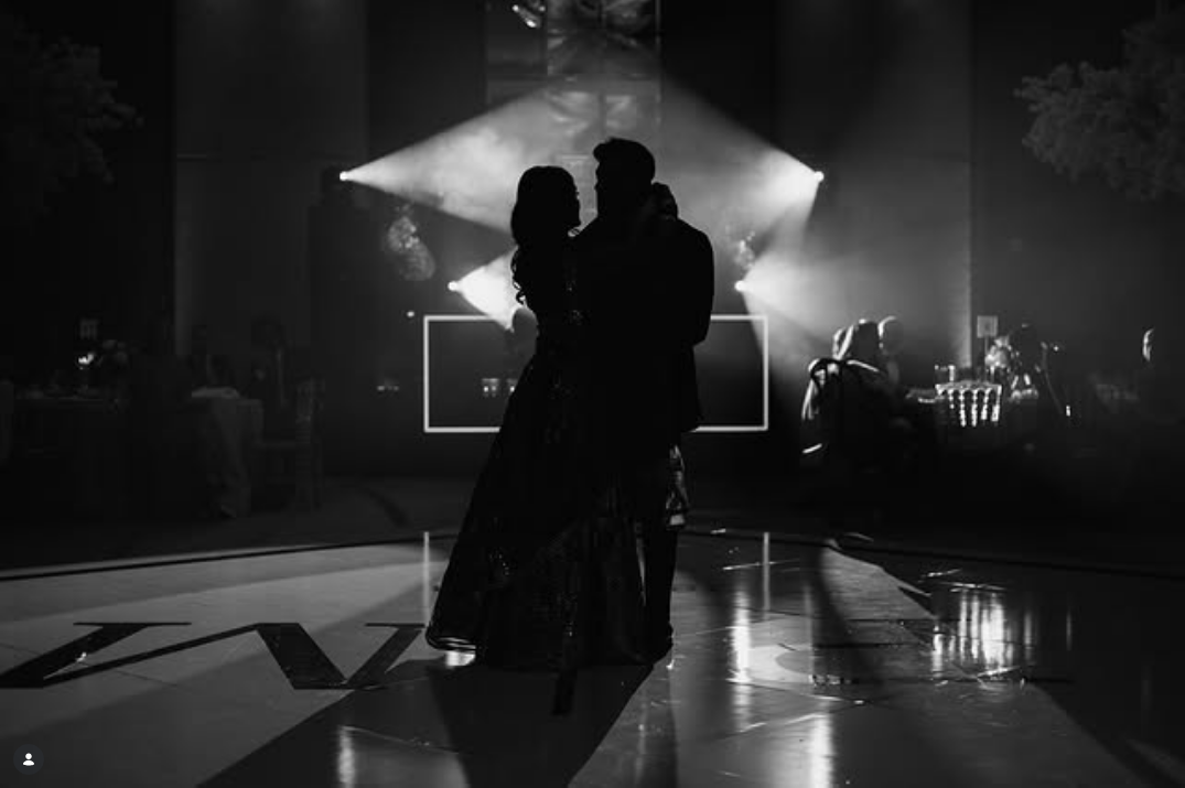 Couple dancing in silhouette on spotlighted dance floor