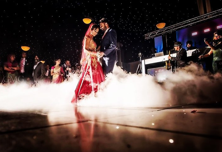 Couple dancing in fog at wedding reception with live musicians